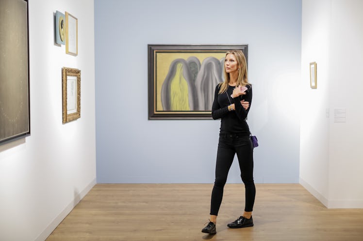 A woman in a black outfit observing artworks at Art Basel Miami Beach 2016.