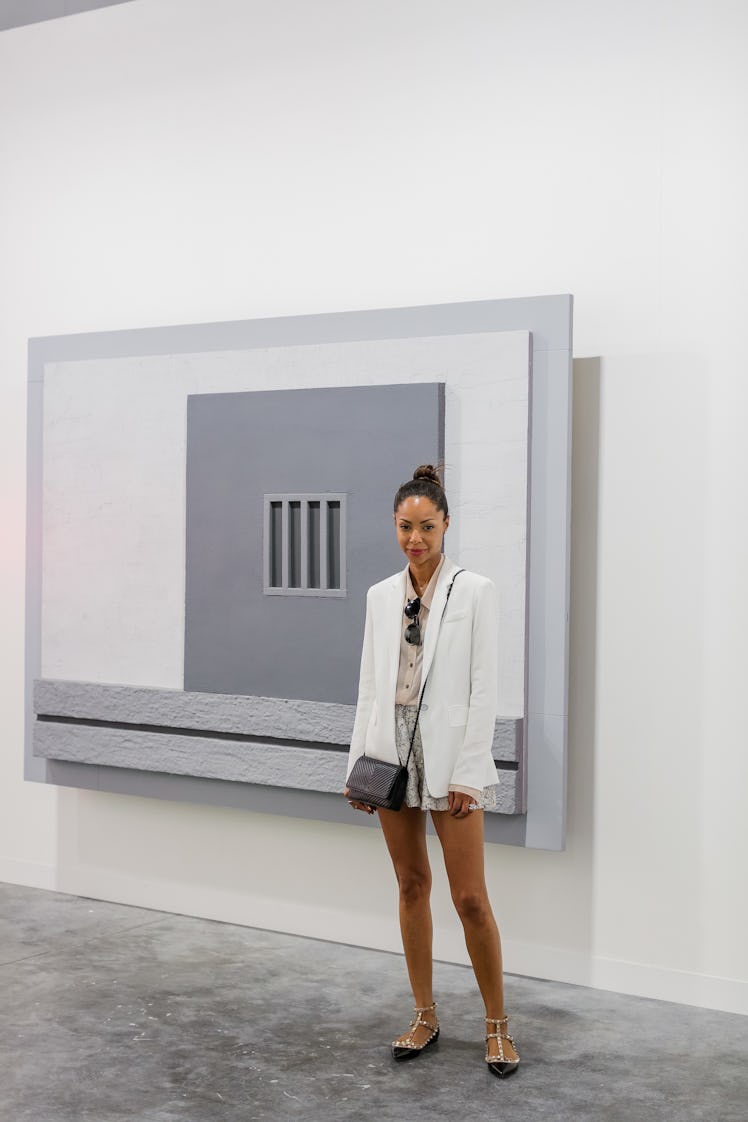 A woman posing next to the artwork at Art Basel Miami Beach 2016