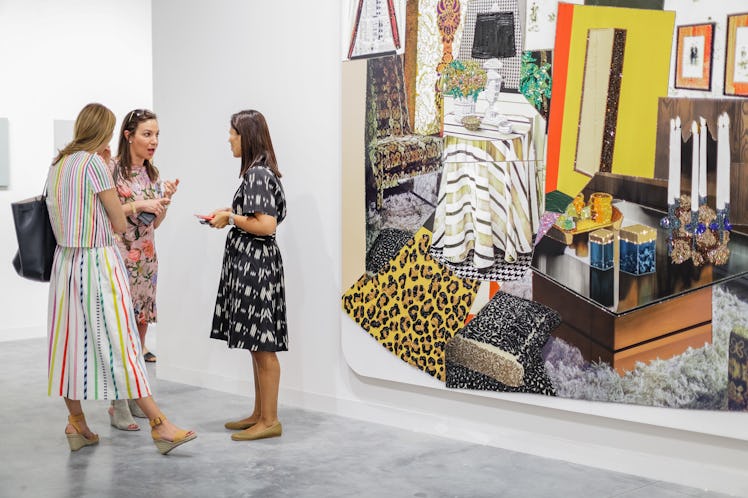 Three women in summer dresses, discussing artwork at Art Basel Miami Beach 2016.