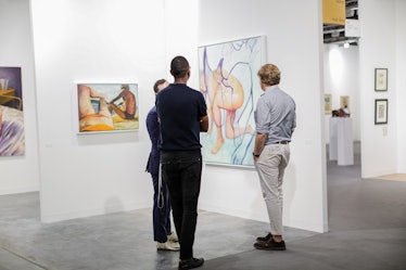 Attendees engrossed in artworks at Art Basel Miami Beach 2016.