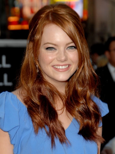 Emma Stone with red wavy hair, wearing a blue dress at the premiere of Superbad in 2007