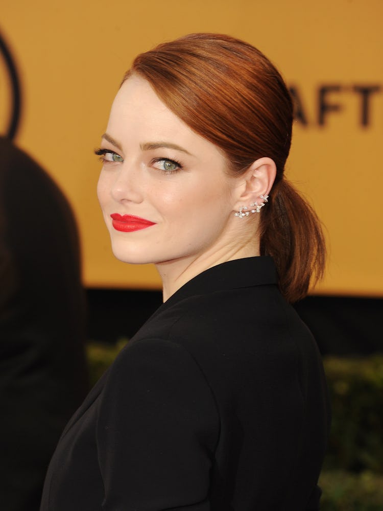 Emma Stone with a sleek side pony, a red lip, and a black winged eye at the 21st Annual Screen Actor...