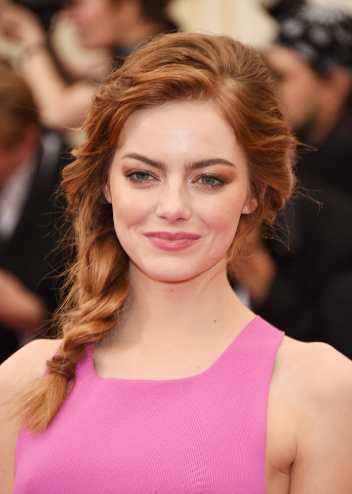 Emma Stone with her red hair in a side braid and a smokey eye look at the 2014 Met Gala