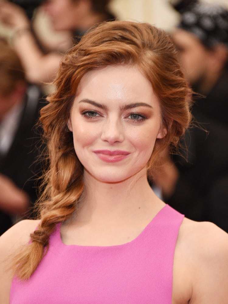 Emma Stone with her red hair in a side braid and a smokey eye look at the 2014 Met Gala