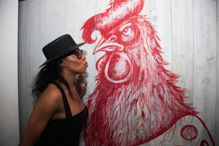 June Ambrose posing next to a rooster graffiti during Public School x Radio party