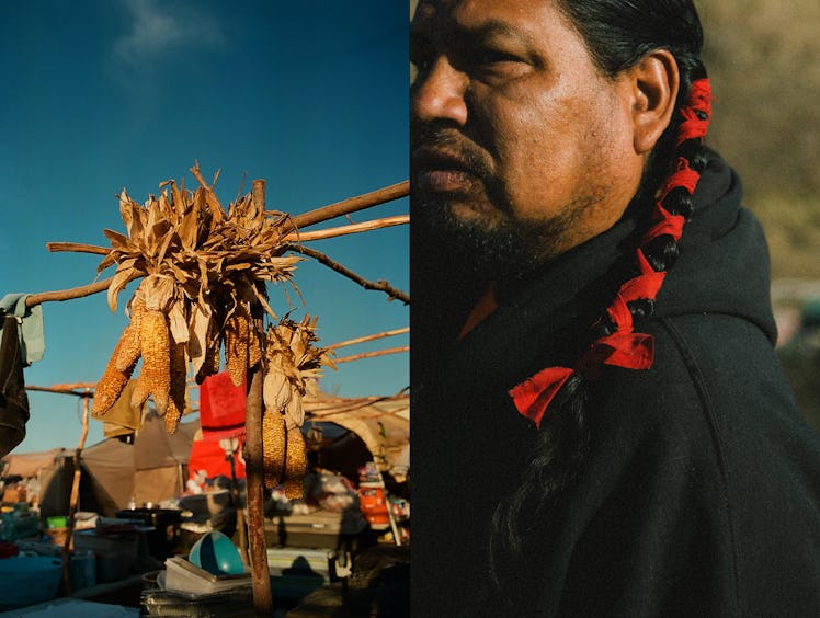 A Native American next to a corn hanging from the stand at Standin Rock.