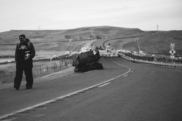 A man walking the road while holding the Bible at Standing Rock