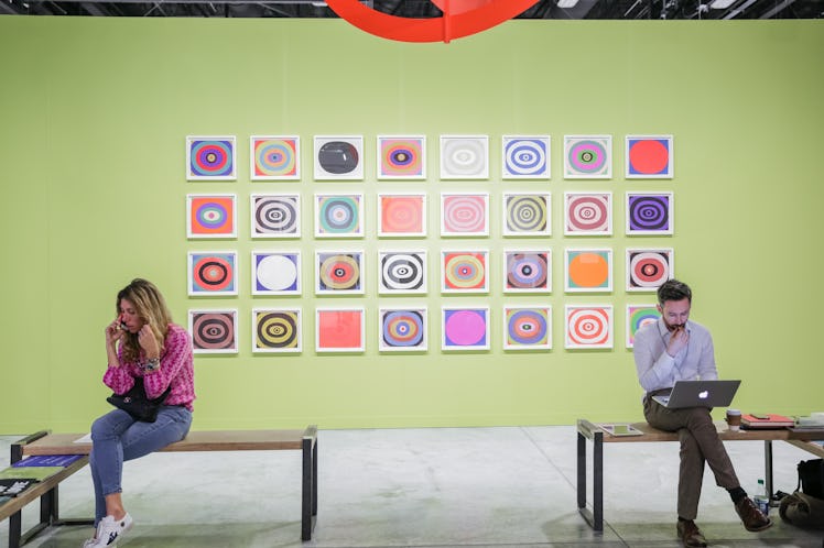 Visitors sitting in front of the artwork at Art Basel Miami Beach 2016.
