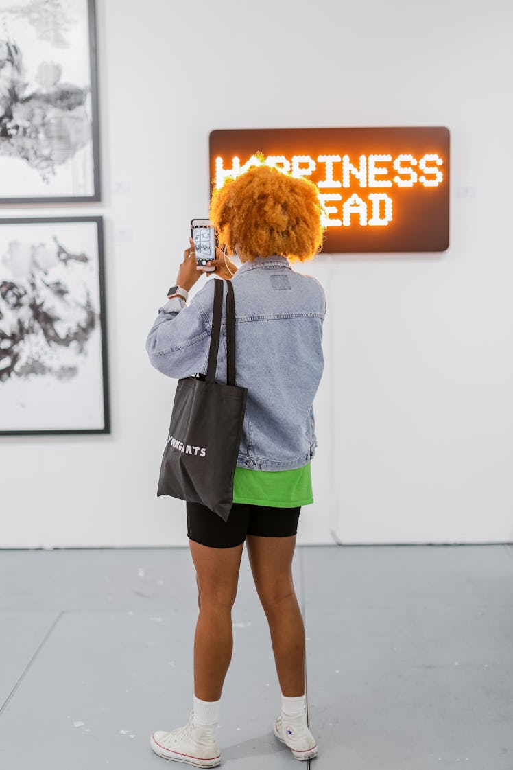 A visitor taking photos of the artwork at Art Basel Miami Beach 2016.