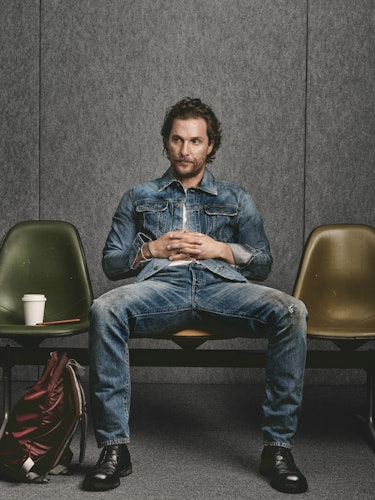 Matthew McConaughey sitting on a chair in a waiting room in a denim shirt and denim trousers