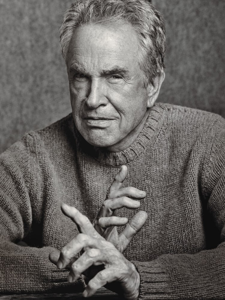 A portrait of Warren Beatty in a sweater posing