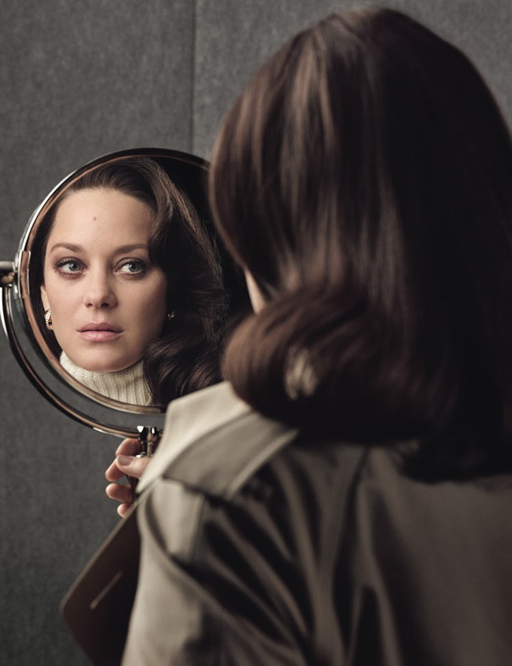 Marion Cotillard in a beige turtleneck and jacket and her reflection in a small round mirror