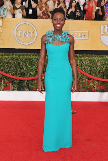 Lupita Nyong’o in a turquoise dress with 3D floral collar at a red carpet event