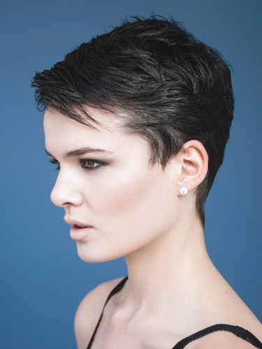 A model with short hair and blue eyeshadow looking into the distance 