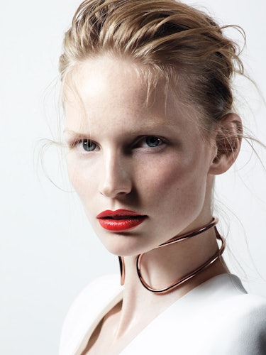 A blonde model with blue eyes and red lipstick looking straight at the camera