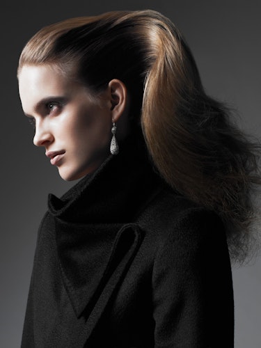 A model with her hair styled as if in a high pony without a hair tie