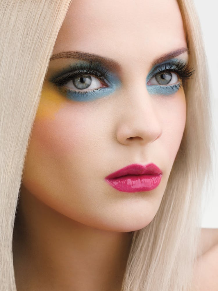 A blonde model with blue eyeshadow on her lids and on her bottom waterline 