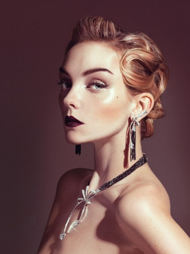 A model with strawberry blonde hair styled in 1920s fashion and long dangly earrings 