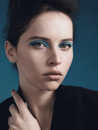 A brunette model with short hair, blue eyeshadow and black winged eyeliner 