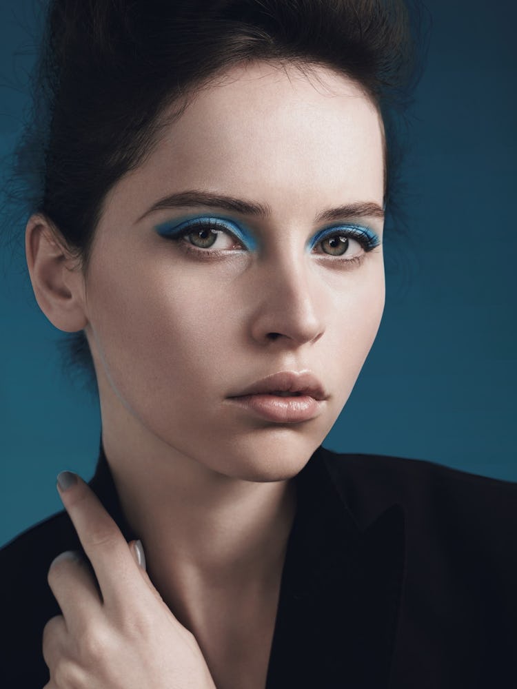 A brunette model with short hair, blue eyeshadow and black winged eyeliner 