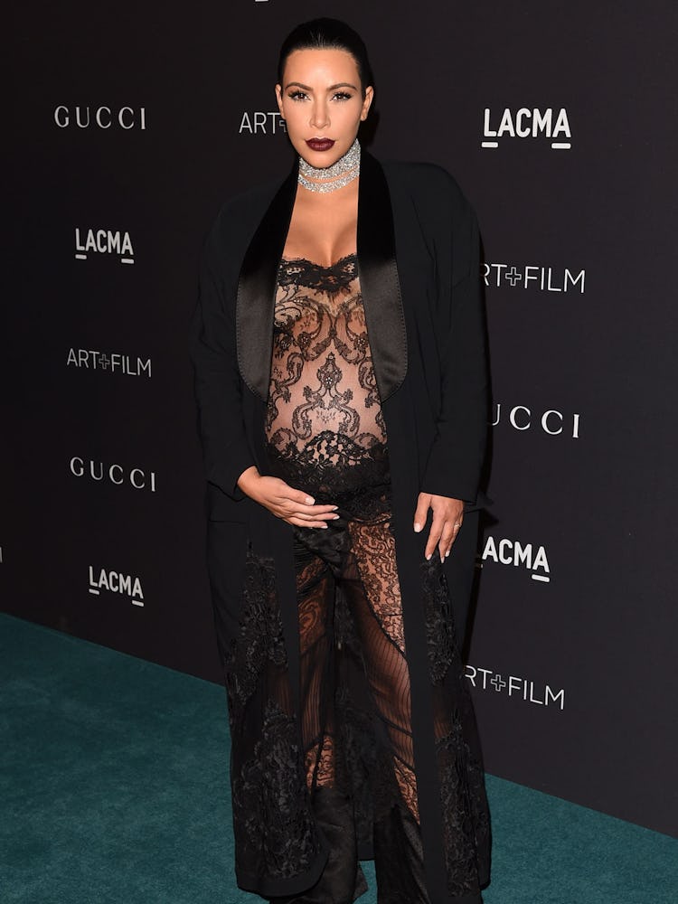 Kim Kardashian posing while wearing a black coat