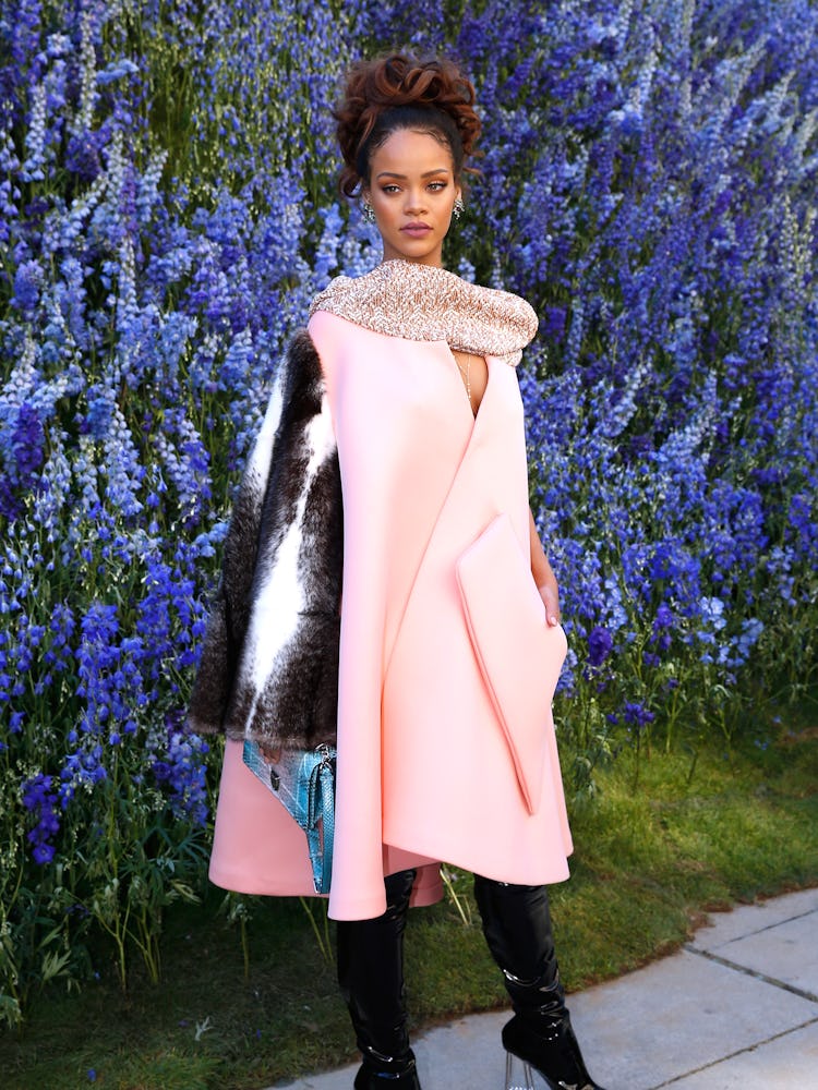 Rihanna posing while wearing a pink Dior coat 