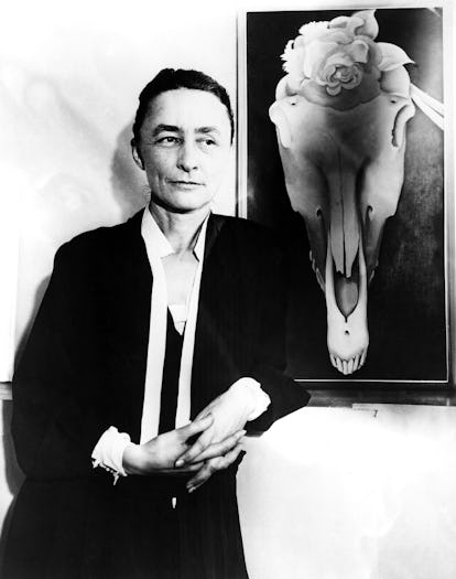 Georgia O’Keeffe posing next to a painting