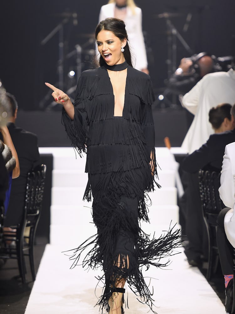 Adriana Lima pointing at the audience while walking the runway at amfAR’s 2015 charity event