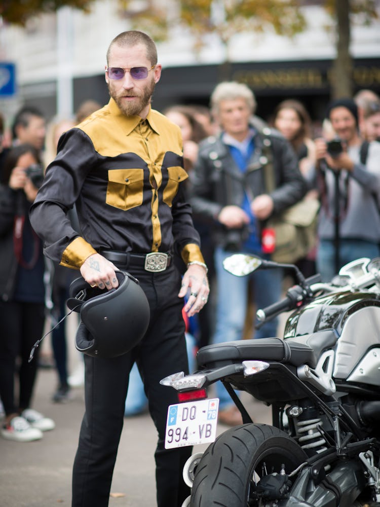 Justin O’Shea standing next to his motorcycle at the 2015 Paris Fashion Week