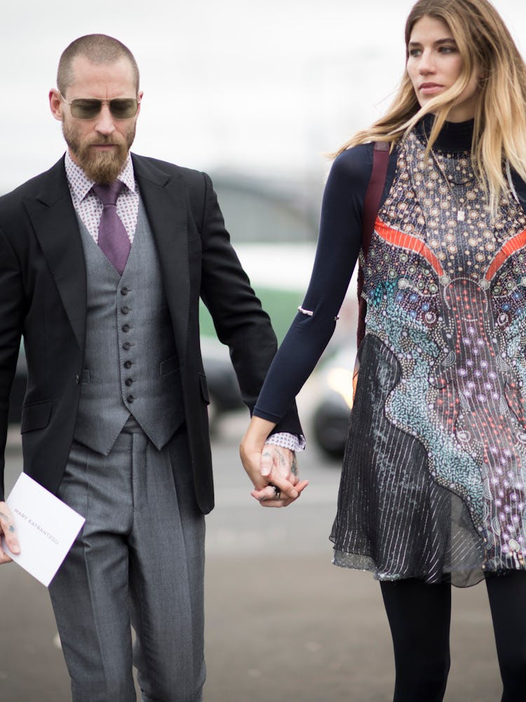 Justin O’Shea and Veronika Heilbrunner walking while holding their hands together at the 2016 London...