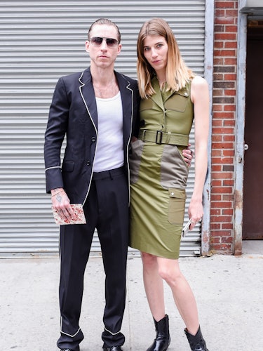 Justin O’Shea in a black blazer and white shirt posing for a photo with Veronika Heilbrunner in a gr...