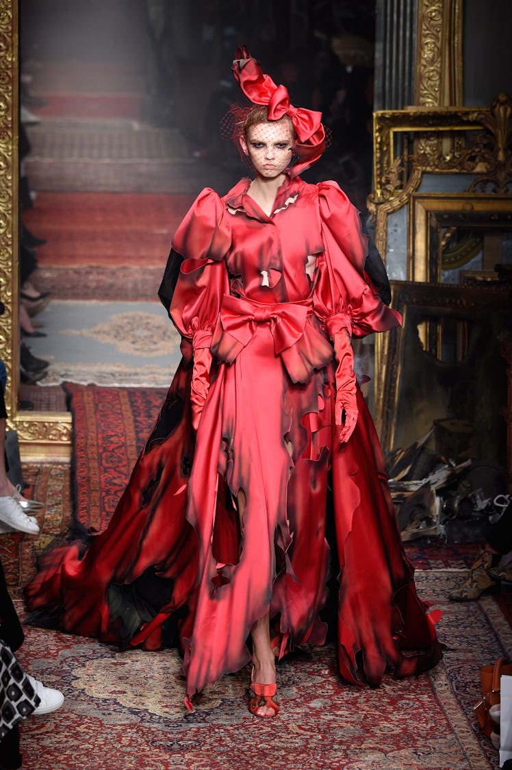 Ruth Bell walking down the runway while wearing a Moschino red gown 