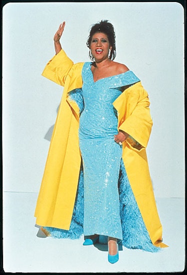 Aretha Franklin in a blue sequin dress and yellow cape in 1990