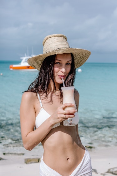 Bella Hadid drinking Pina Colada on a beach 