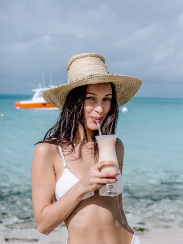 Bella Hadid having a cocktail next to the sea while promoting Fyre Festival