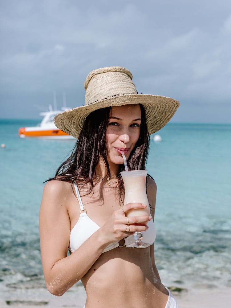 Bella Hadid having a cocktail next to the sea while promoting Fyre Festival