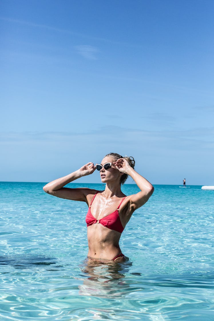 Model in red bikini, posing in the sea