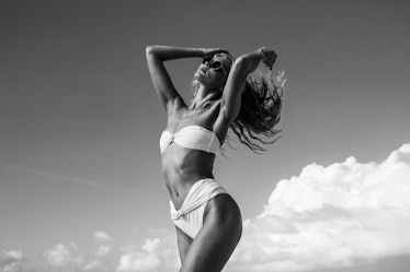 Model posing on a beach in a bikini, in black and white