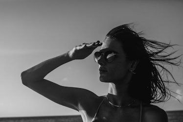 Alessandra covering her eyes from the sun, in black and white 