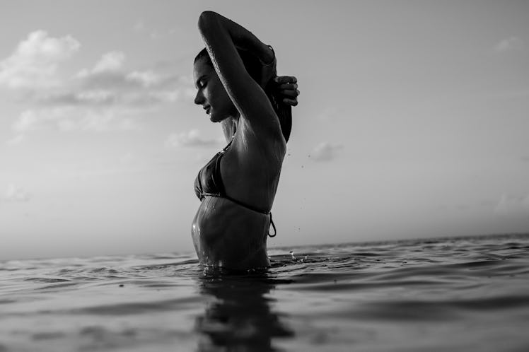 Alessandra Ambrosio squeezing her hair while getting out of a water 