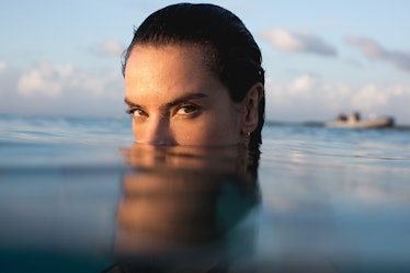 Alessandra Ambrosio peeking out of a water while looking straight into camera