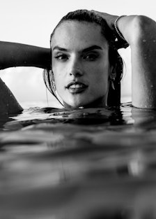 Alessandra Ambrosio in neck-deep water with her hands on her head