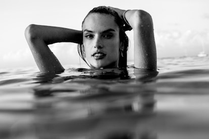 Alessandra Ambrosio in neck-deep water with her hands on her head