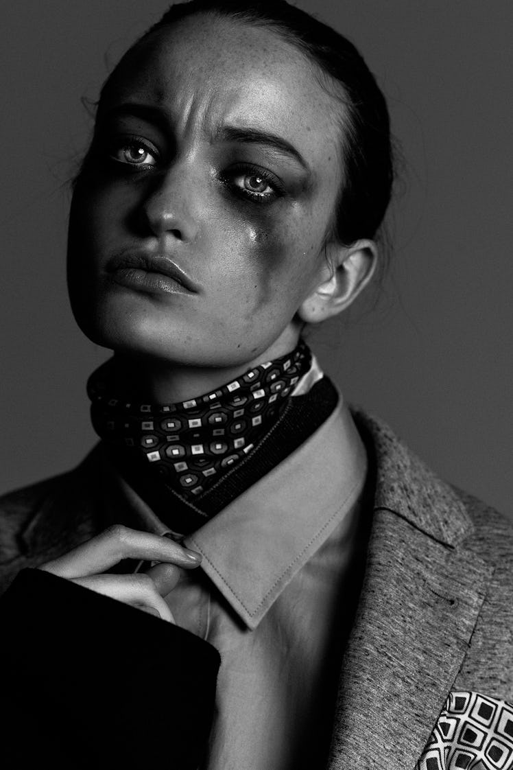 Face of a female model with blurred black eye makeup over her cheeks 