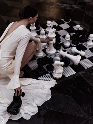 “In the Youth of Our Fury” photo essay part by Margaret Zhang with a woman playing chess in a white ...