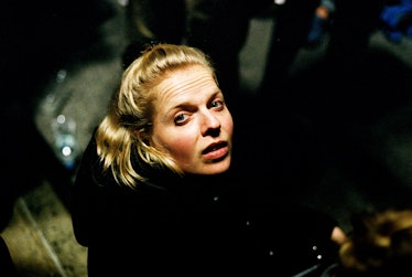 A blonde woman in a black jacket looking up by Alex Hodor-Lee