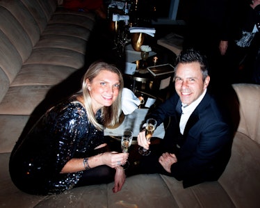 A man and woman having drinks on a couch at New Year’s Eve Blacktie Party at The Top of The Standard...