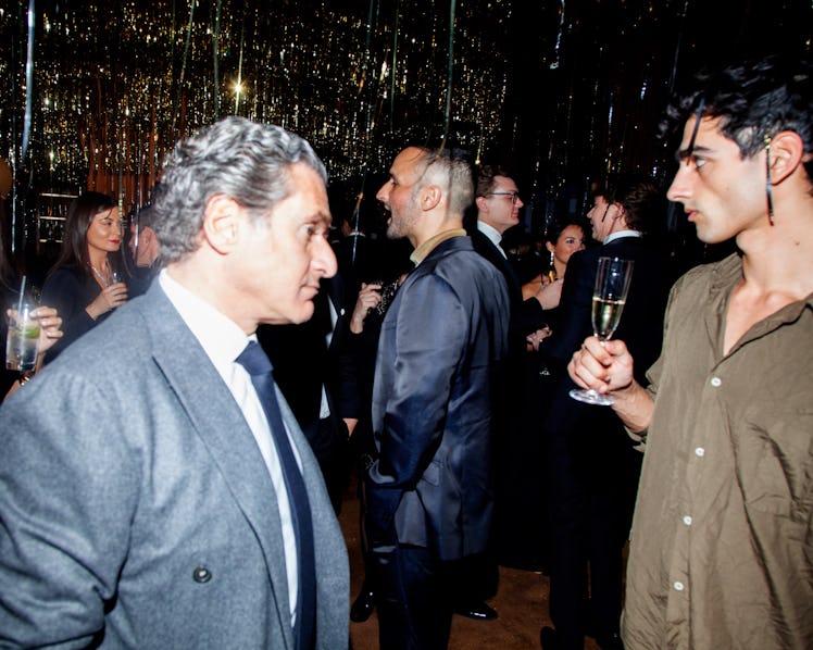 A man in a suit talking to a man in a button-up holding a drink at New Year’s Eve Blacktie Party at ...