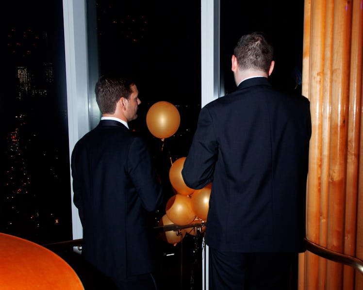 Two men with their backs turned talking at the New Year’s Eve Blacktie Party at The Top of The Stand...