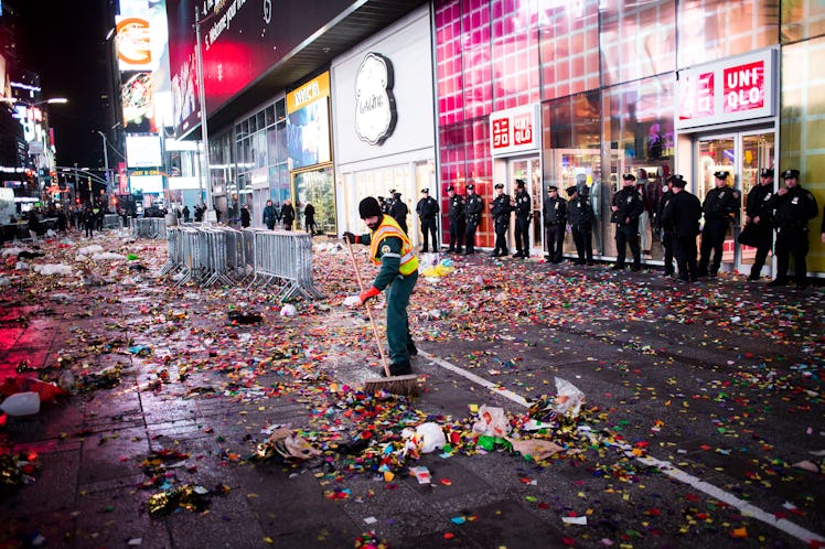 A man cleaning confetti from the street after New Year's Eve 2017 celebration at Times Square. 